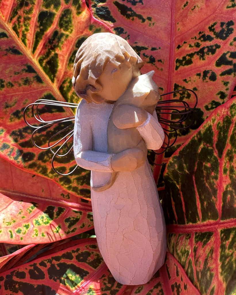 Garden sculpture of angel holding a kitten